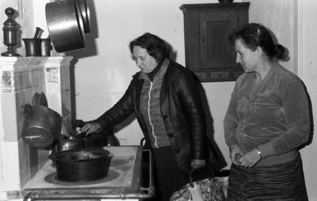 Prezentacja tradycyjnego wyposażenia kuchennego we wnętrzu skansenowego domu podczas zwiedzania po otwarciu (kliknięcie powiększy zdjęcie)