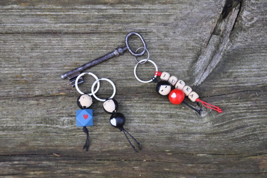 Na drewnianej podstawie leży klucz i breloczki wykonane z drewnianych elementów. Jeden z breloczków ma napis Julka (kliknięcie spowoduje powiększenie zdjęcia)