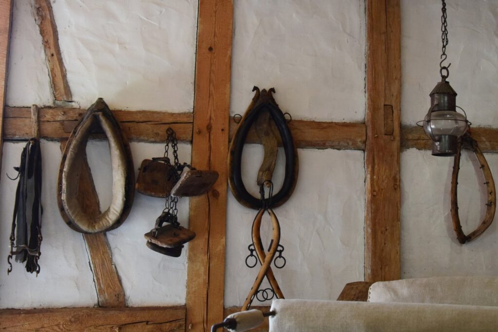 Zestaw tradycyjnych narzędzi kowalskich zawieszonych na ścianie kuźni, w tym szczypce i młotki (kliknięcie powiększy zdjęcie)