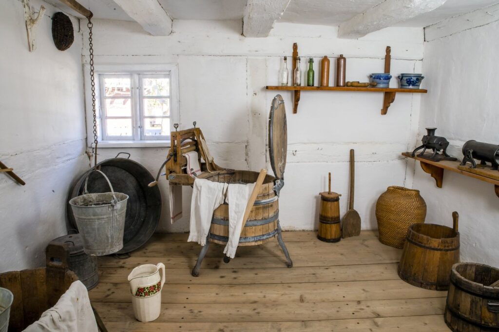 Pomieszczenie gospodarcze w chałupie, w którym znajdują się: beczki, wiadra, narzędzia oraz wyposażenie do prac domowych (kliknięcie powiększy zdjęcie).