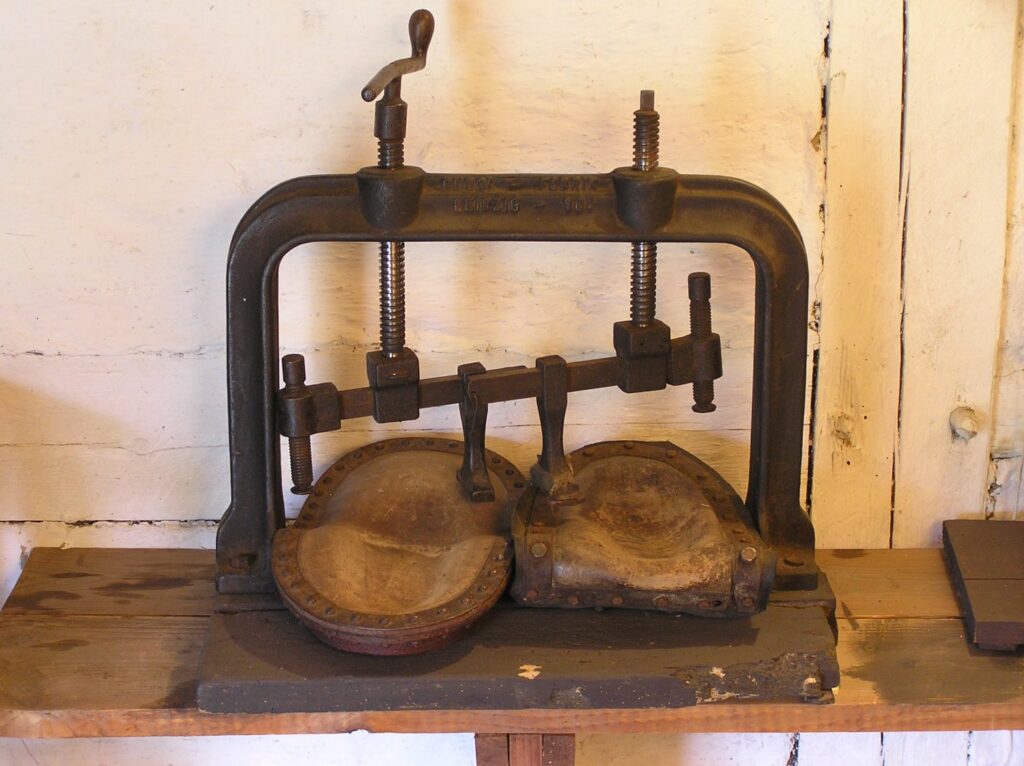 Prasa szewska z metalowym stelażem i drewnianymi formami, wykorzystywana do kształtowania elementów obuwia (kliknięcie powiększy zdjęcie).