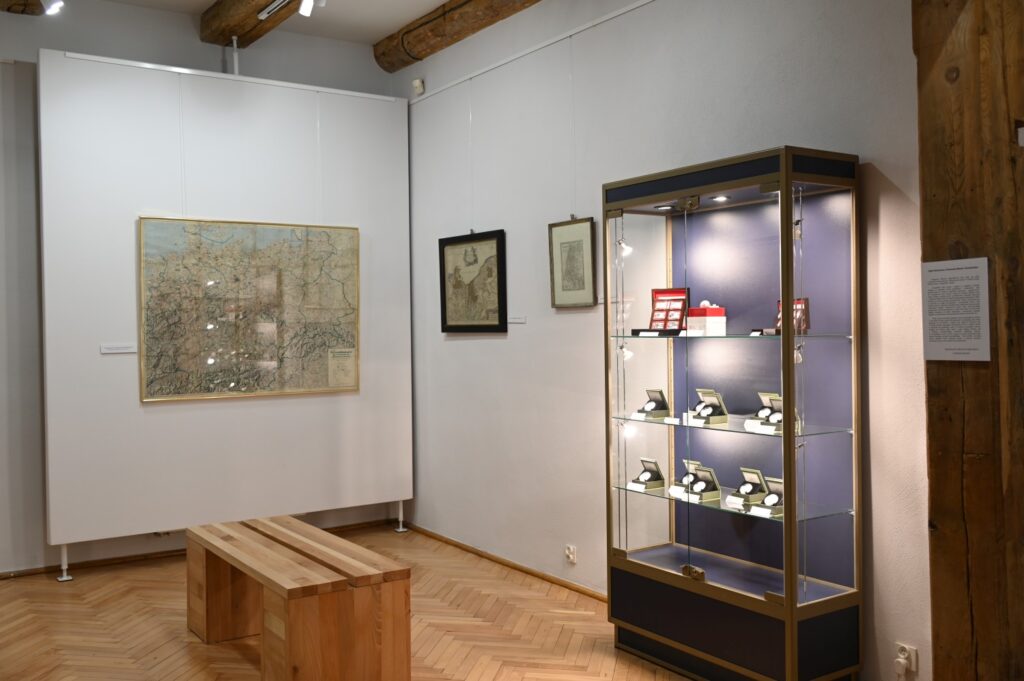 Gablota z monetami ze zbiorów Muzeum w Koszalinie oraz mapy pochodzące obrazujące Koszalin i okolice w dawnych latach (kliknięcie spowoduje powiększenie zdjęcia).