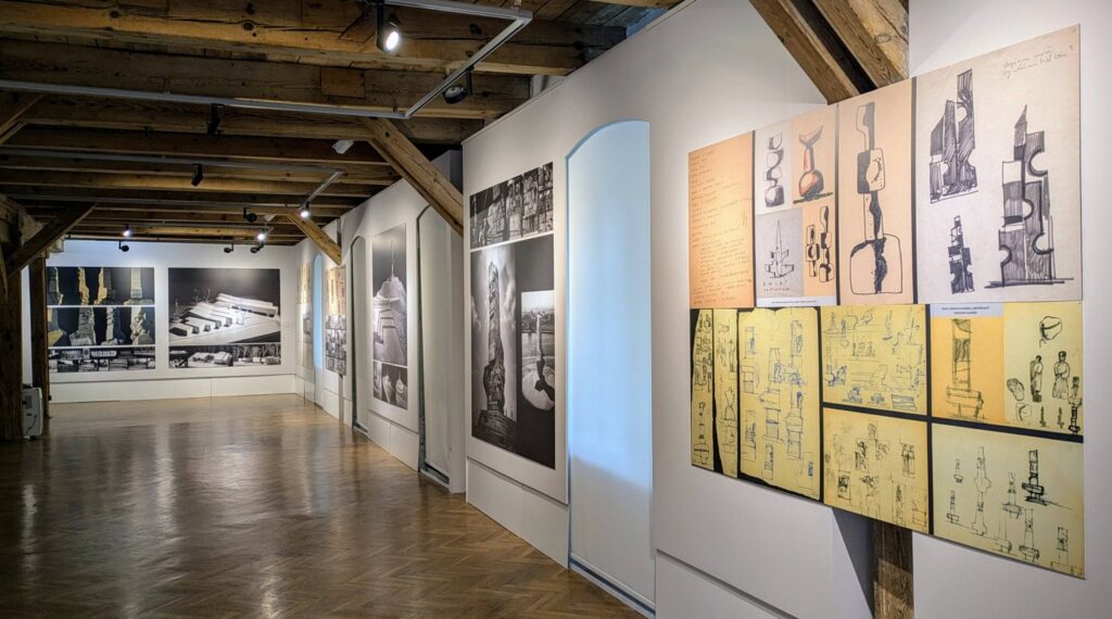 Sala wystawowa z zawieszonymi na ścianach planszami ze szkicami projektowymi pomników (kliknięcie spowoduje powiększenie zdjęcia)