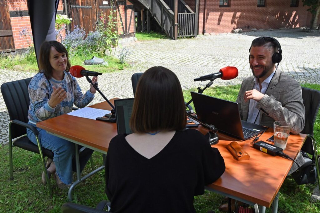 Irena Nowogrodzka-Barańska przed mikrofonem w studiu plenerowym Radia Koszalin (kliknięcie spowoduje powiększenie zdjęcia).