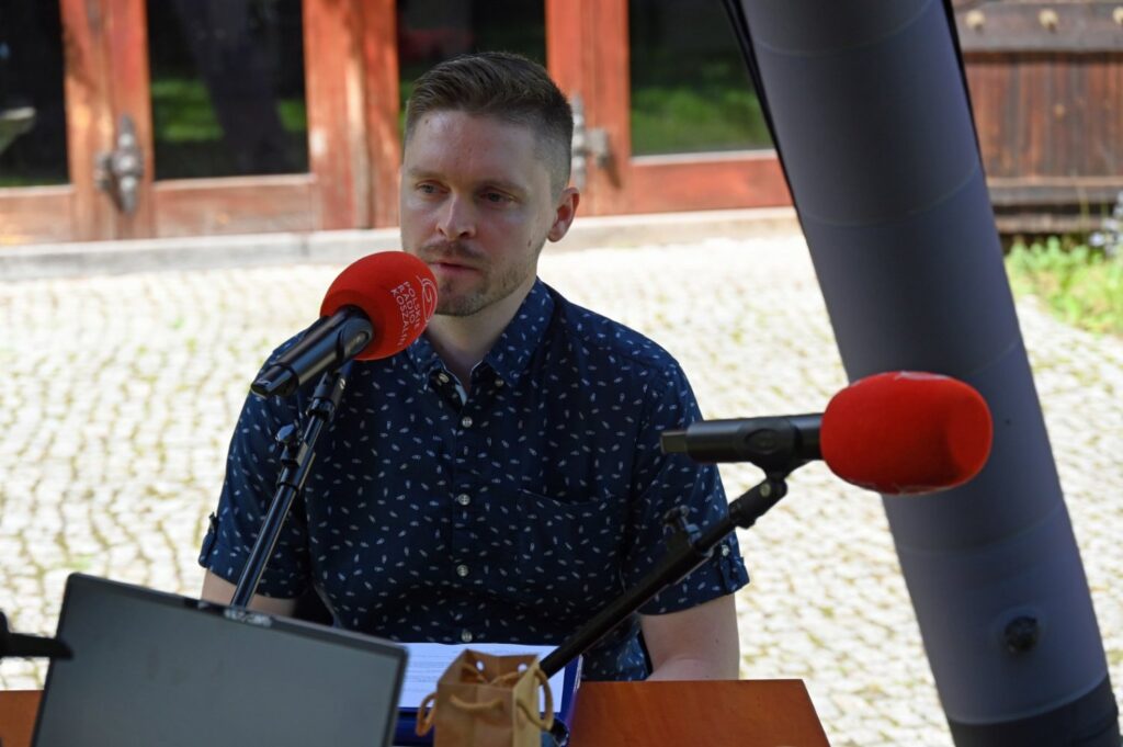 Łukasz Rozmarynowski przy mikrofonie studia plenerowego Radia Koszalin (kliknięcie spowoduje powiększenie zdjęcia).