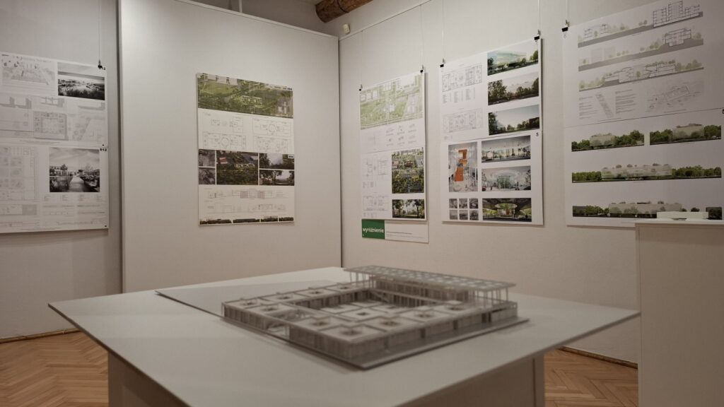 Makieta pracy konkursowej Ekofuturium. W tle, zawieszone na ścianie plansze z grafikami i wizualizacjami projektów.