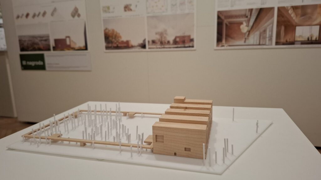 Makieta pracy konkursowej Ekofuturium. W tle plansze z grafikami i wizualizacjami projektów.