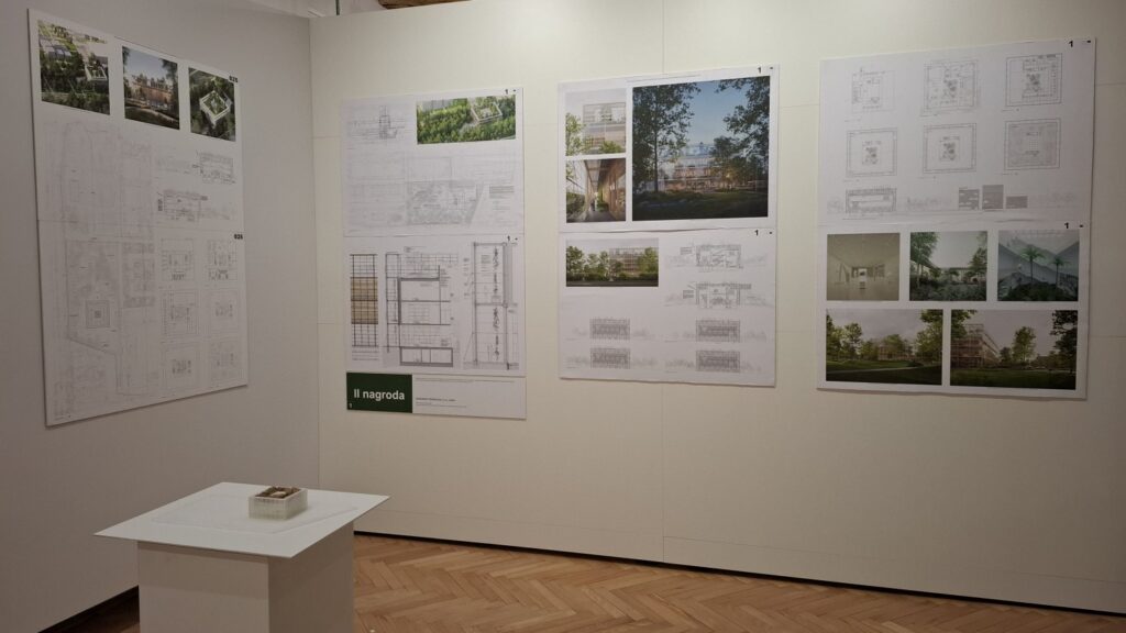 Powieszone na ścianie plansze z grafikami i wizualizacjami prac konkursowych Ekofuturium.