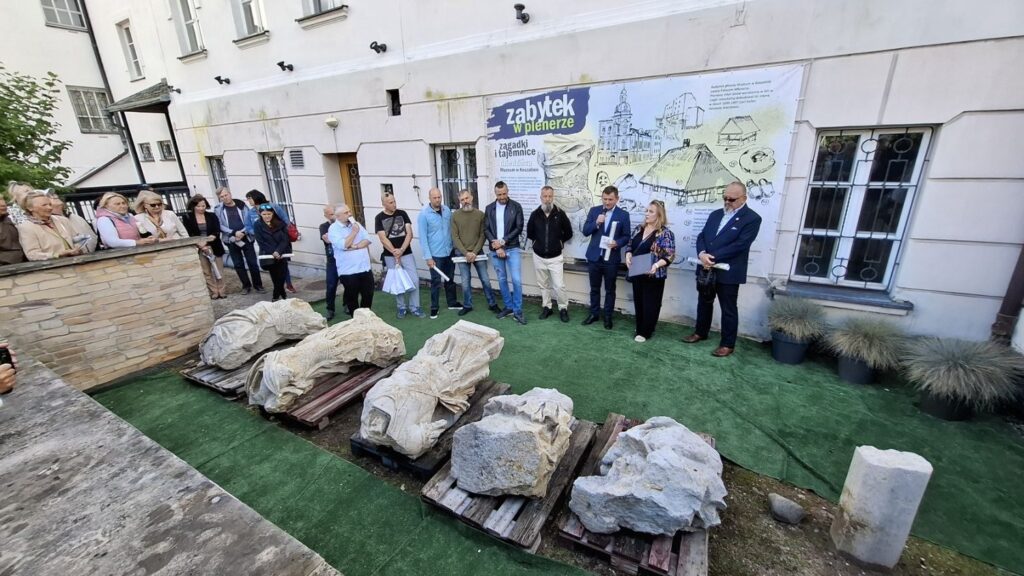 Ludzie stoją przed budynkiem muzeum. W tle baner wystawy "Zabytek w plenerze", a przed ludźmi elementy pomnika Fryderyka Wilhelma I (kliknięcie spowoduje powiększenie zdjęcia).