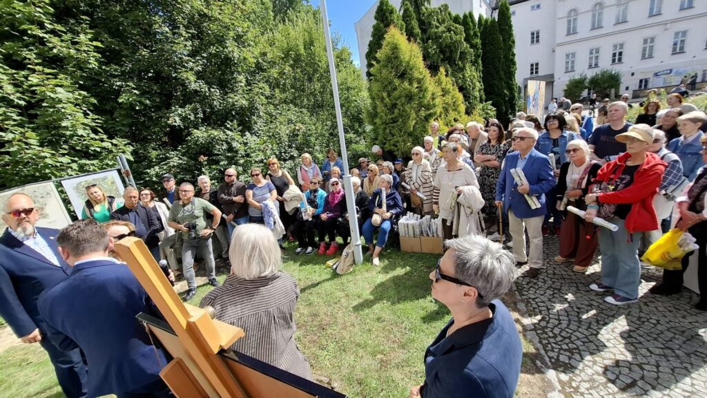 Ludzie stoją na zewnątrz, na dziedzińcu muzeum. Po prawej Prezydent Koszalina i Dyrektor Muzeum. W tle widoczny budynek muzeum (kliknięcie spowoduje powiększenie zdjęcia).