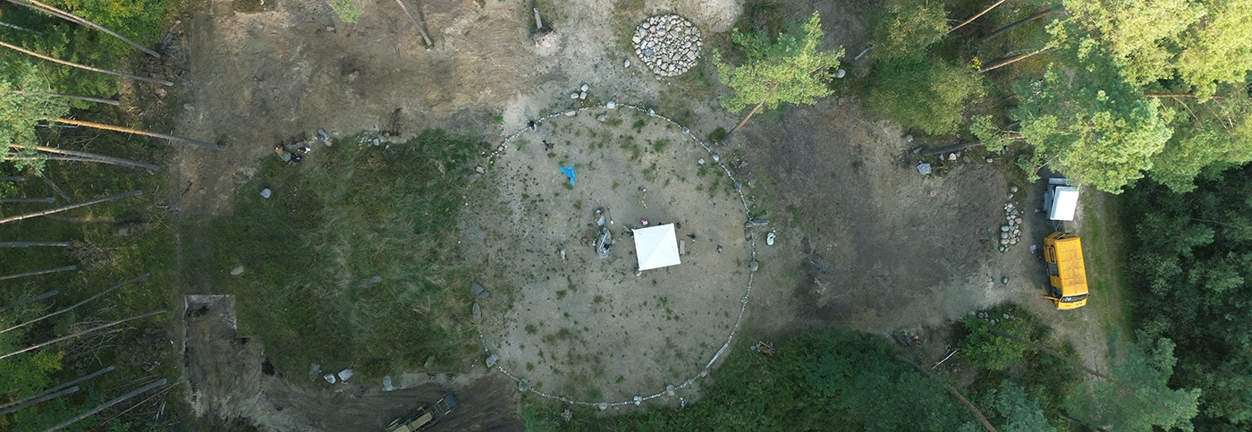 Kamienne kręgi w Pławnie z drona. Wokół kręgów drzewa.