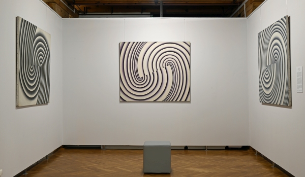 Widok sali wystawowej z trzema obrazami o spiralnych, geometrycznych wzorach (kliknięcie powiększy zdjęcie).