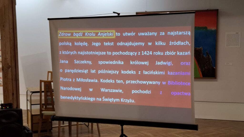 Ekran projekcyjny z planszą tekstową prezentacji wyświetlaną podczas wykładu w muzeum (kliknięcie powiększy zdjęcie)