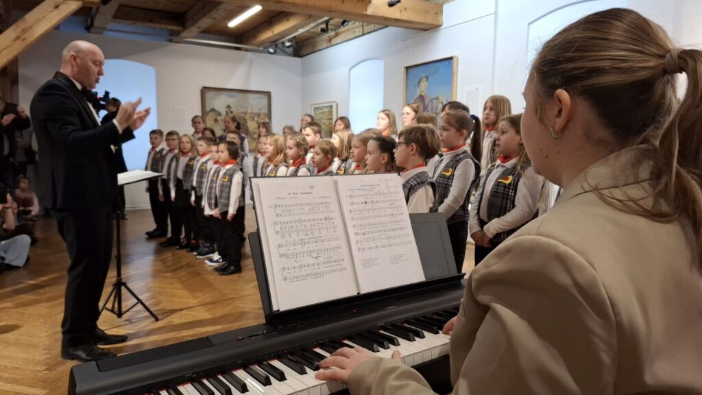 Dyrygent i akompaniatorka przy pianinie podczas występu dziecięcego chóru w muzeum (kliknięcie powiększy zdjęcie)