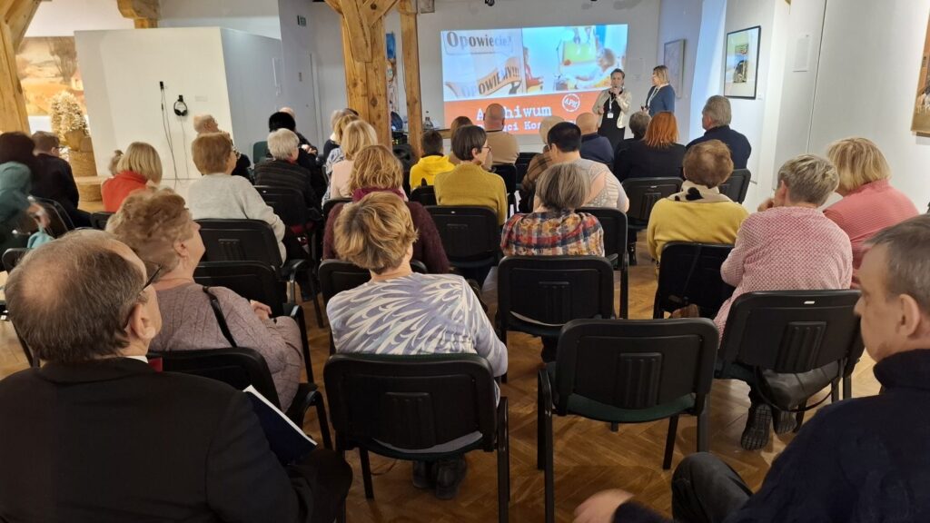 Publiczność siedząca na sali wystawowej podczas spotkania, widok od strony tyłu sali (kliknięcie powiększy zdjęcie)