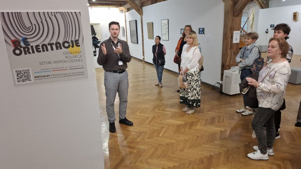 Kurator wystawy rozpoczyna oprowadzanie po wystawie sztuki współczesnej, przedstawiając zwiedzającym temat ekspozycji „Reorientacje” (kliknięcie powiększy zdjęcie).