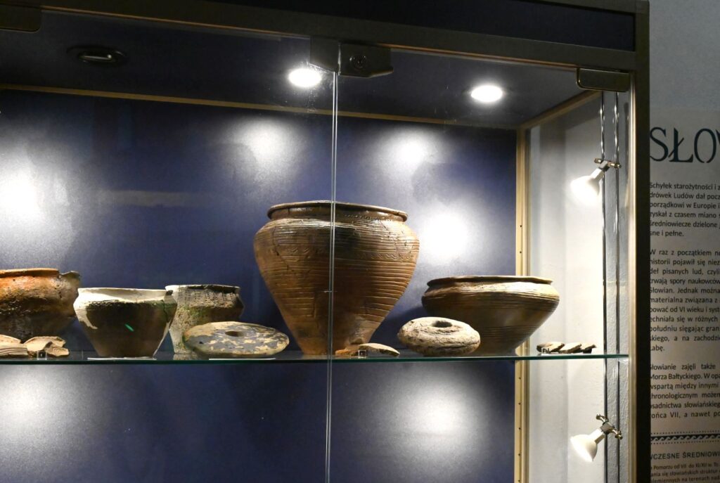 Zbliżenie na gablotę z ceramicznymi naczyniami odkrytymi podczas badań archeologicznych prowadzonych na terenie średniowiecznego Koszalina (kliknięcie powiększy zdjęcie).