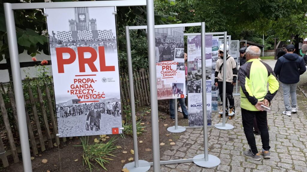 Plenerowa wystawa plansz poświęconych czasom PRL; na pierwszym planie widoczna jest plansza z napisem „PRL. Propaganda – rzeczywistość”, a w tle znajdują się kolejne plansze z archiwalnymi fotografiami i materiałami (kliknięcie powiększy zdjęcie).