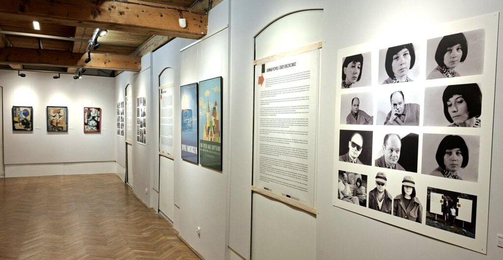 Widok fragmentu sali wystawowej z planszami tekstowymi, archiwalnymi fotografiami portretowymi oraz oprawionymi grafikami na ścianach (kliknięcie powiększy zdjęcie).